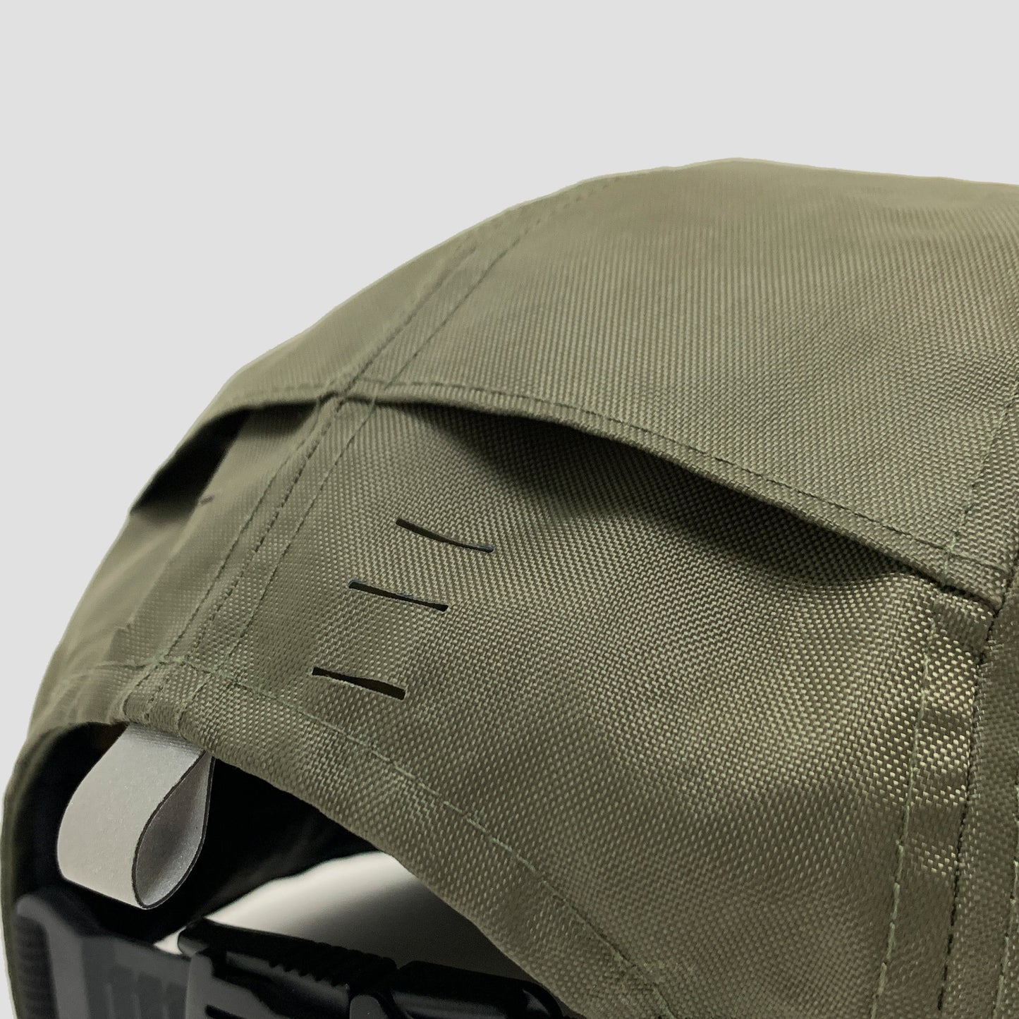 Utility hat made of durable waterproof coated ECOPAK™ fabric, with multiple laser-cut slits and ventilation openings, quick release adjustment strap, and reflexive tab for night time visibility.