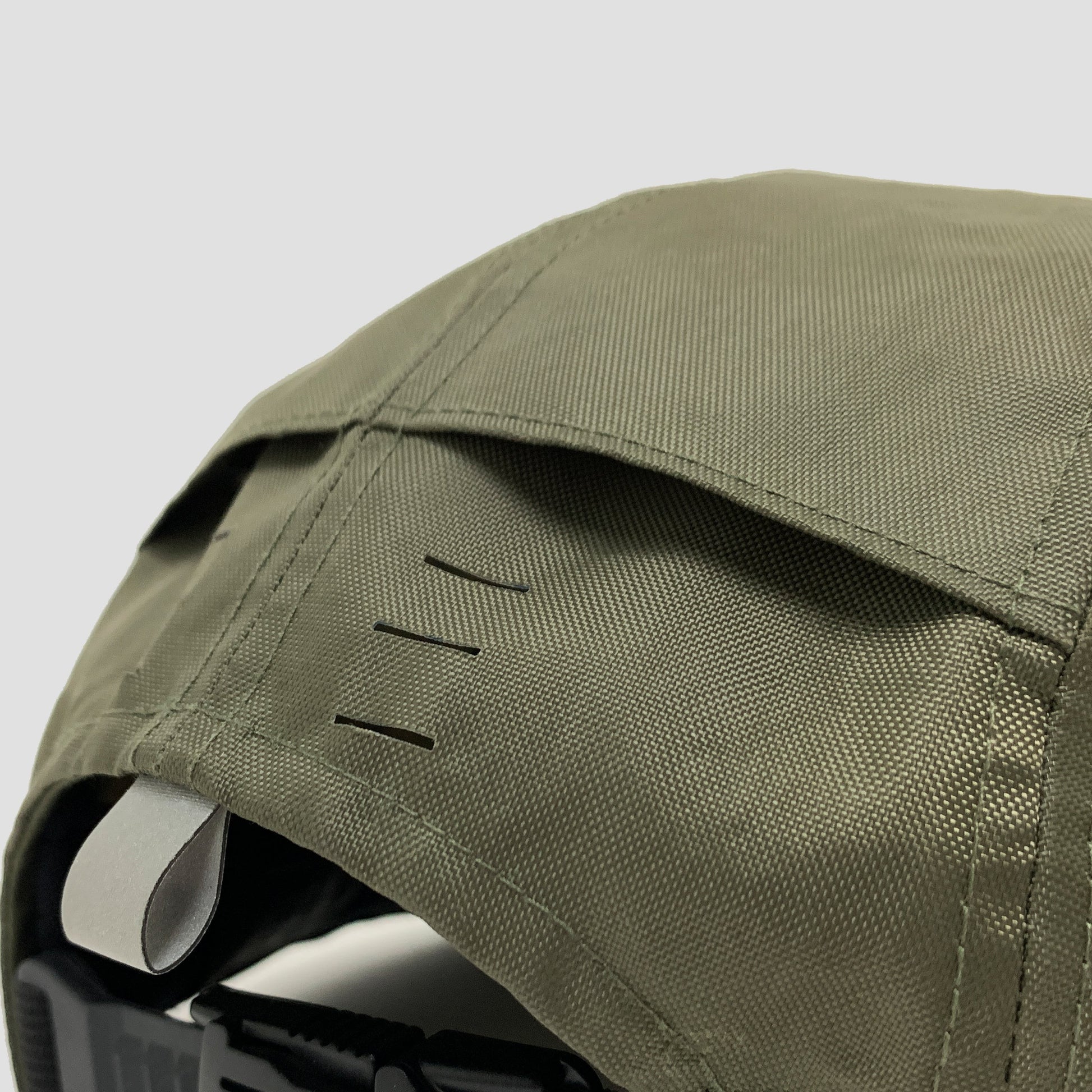 Utility hat made of durable waterproof coated ECOPAK™ fabric, with multiple laser-cut slits and ventilation openings, quick release adjustment strap, and reflexive tab for night time visibility.