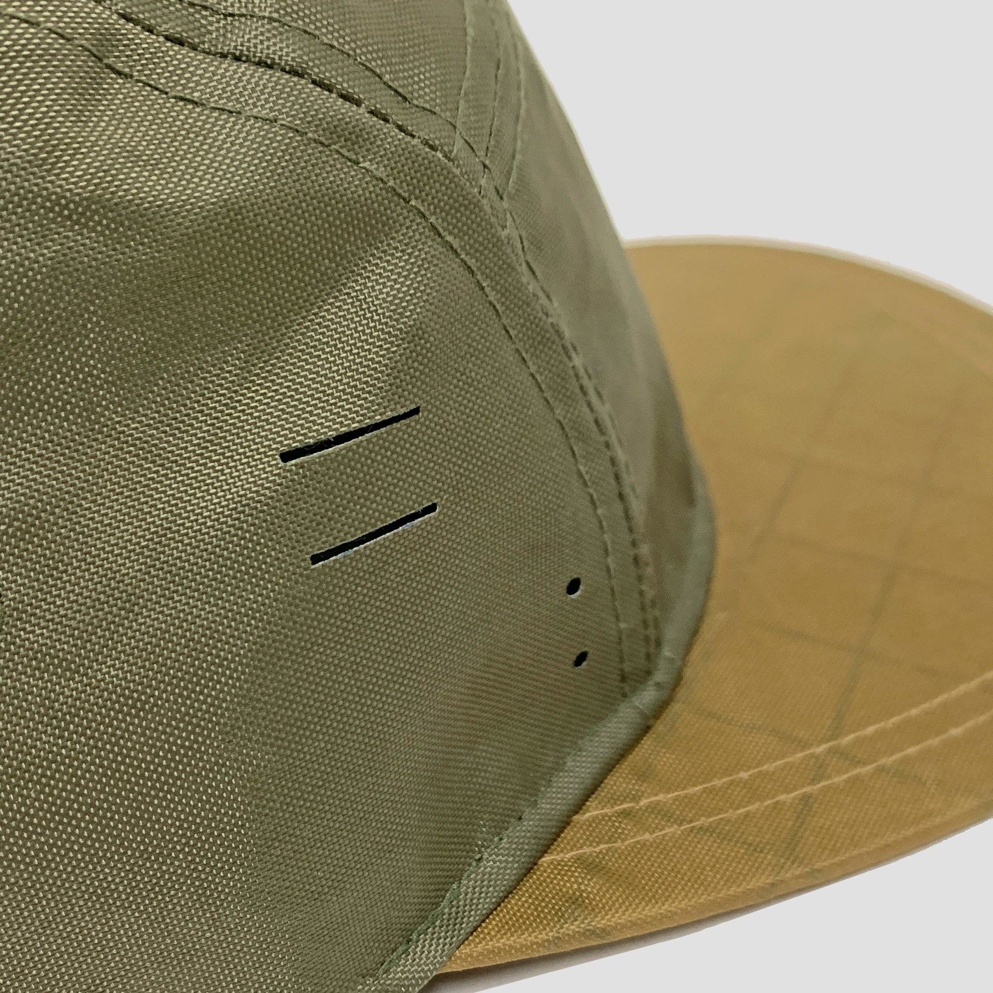 Utility hat made of durable waterproof coated ECOPAK™ fabric, with multiple laser-cut slits and ventilation openings, quick release adjustment strap, and reflexive tab for night time visibility.