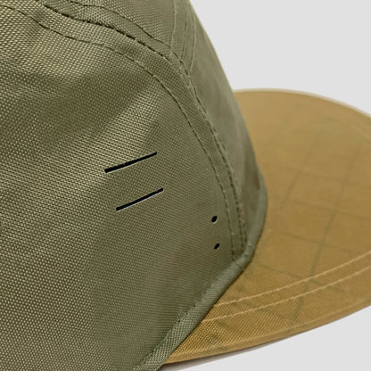 Utility hat made of durable waterproof coated ECOPAK™ fabric, with multiple laser-cut slits and ventilation openings, quick release adjustment strap, and reflexive tab for night time visibility.