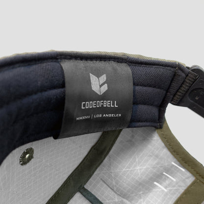 Utility hat made of durable waterproof coated ECOPAK™ fabric, with multiple laser-cut slits and ventilation openings, quick release adjustment strap, and reflexive tab for night time visibility.