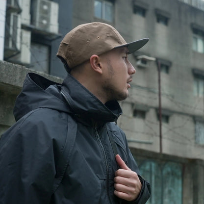 Utility hat made of durable waterproof coated ECOPAK™ fabric, with multiple laser-cut slits and ventilation openings, quick release adjustment strap, and reflexive tab for night time visibility.